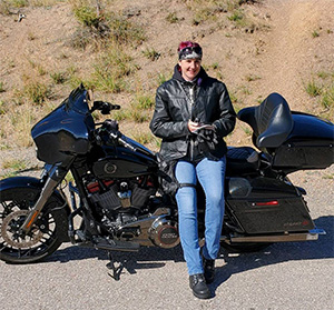 Smiling woman leaning against her motorcycle